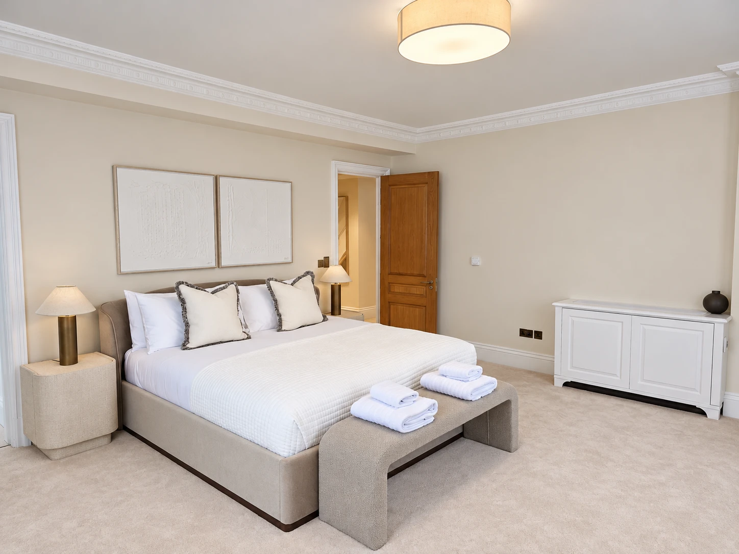Immaculate finished bedroom with neutral walls, crisp white bedding and detailed cornicing