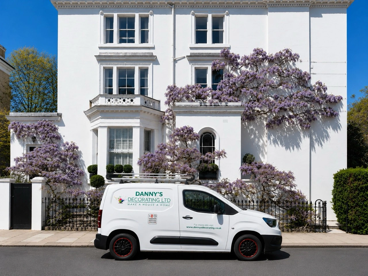 Danny's Decorating van outside a white townhouse with flowering wisteria